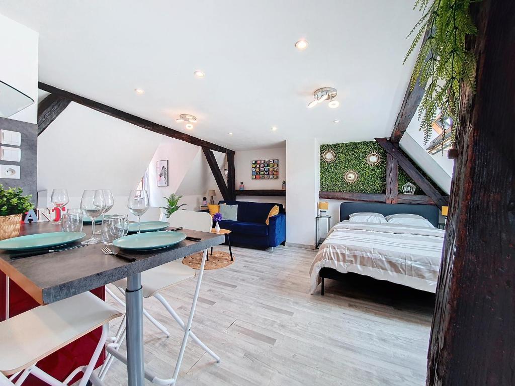 ein Schlafzimmer mit einem Bett und einem Tisch mit Stühlen in der Unterkunft LE MARCARON - Hypercentre Obernai - Confort - Lumineux in Obernai