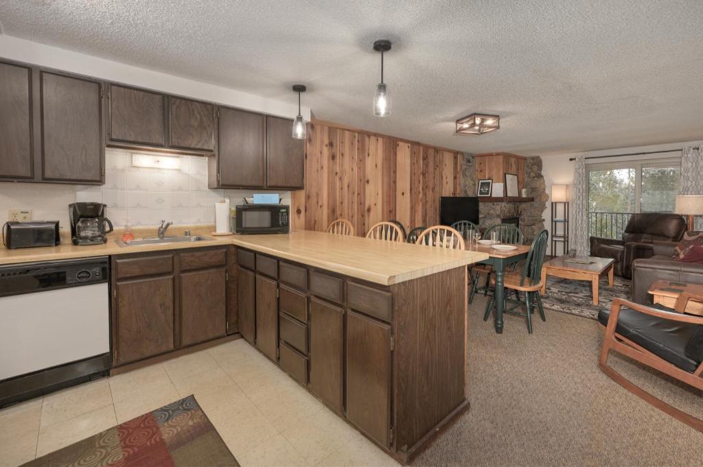 a kitchen with wooden cabinets and a living room at Beaver Village Unit #0623R in Winter Park