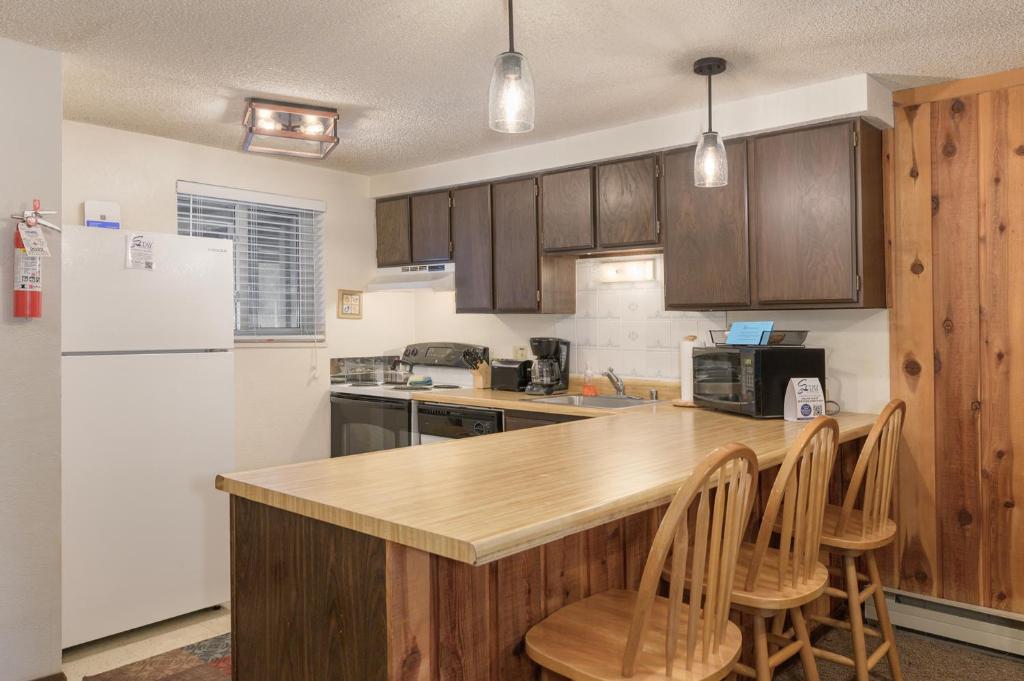 a kitchen with a white refrigerator and wooden cabinets at Beaver Village Unit #0623R in Winter Park