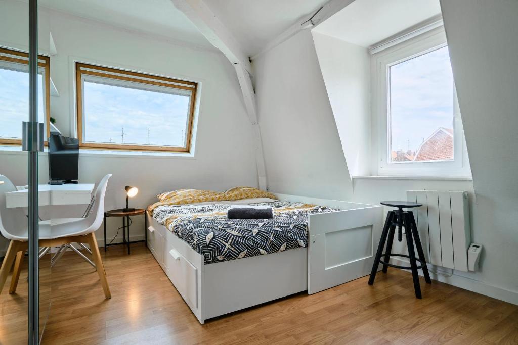 une petite chambre avec un lit et un bureau dans l'établissement Lille Centre, Studio Idéal, à Lille