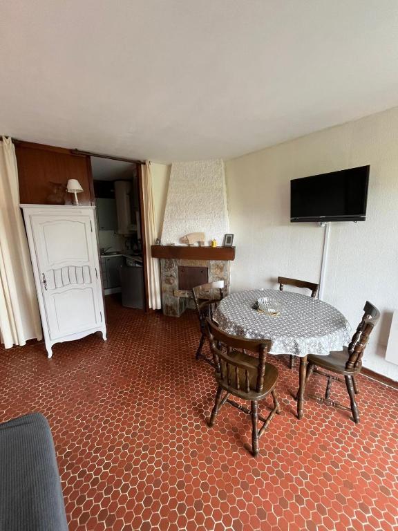 une pièce avec une table, des chaises et une télévision dans l'établissement Pla d'Adet- Studio 4 personnes Armazan, à Saint-Lary-Soulan