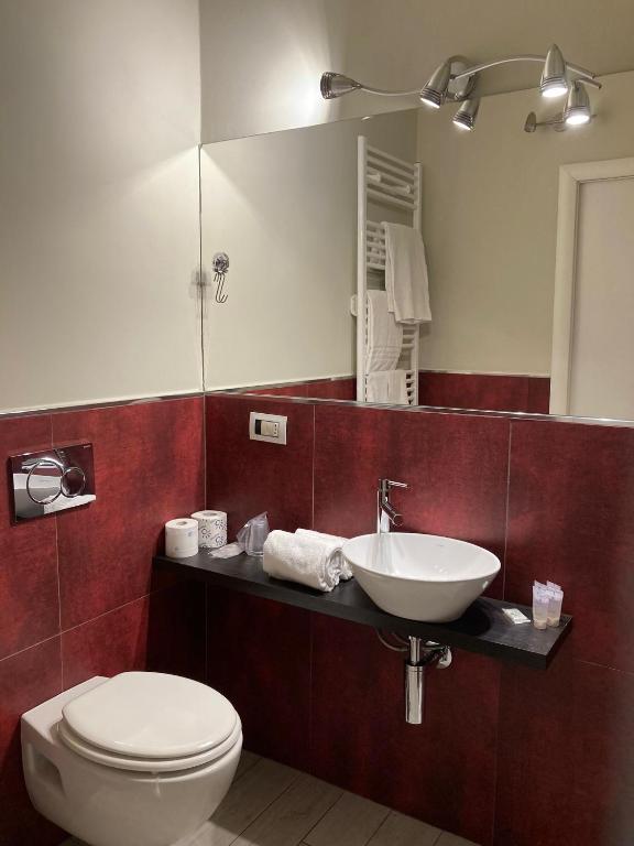 a bathroom with a toilet and a sink and a mirror at Adalesia Hotel & Coffee in Turin