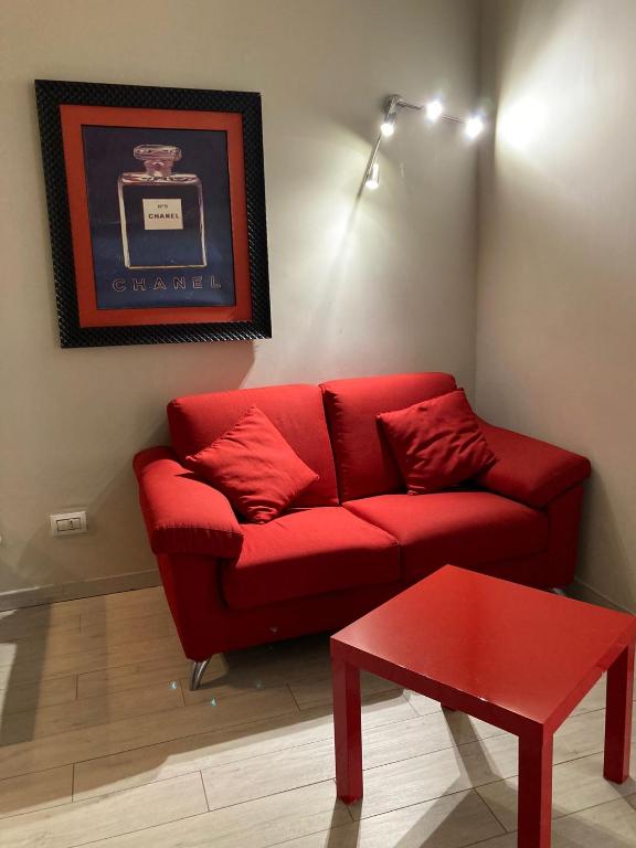 a red couch with red pillows in a living room at Adalesia Hotel & Coffee in Turin