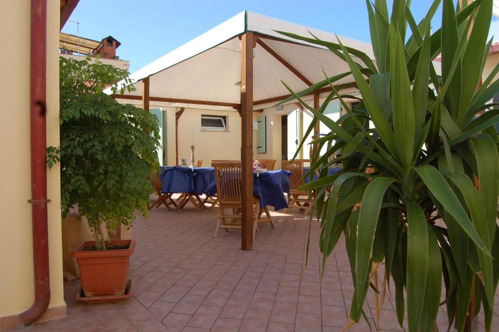 a patio with a table and chairs under a tent at La Papaya in Marina di Pisa