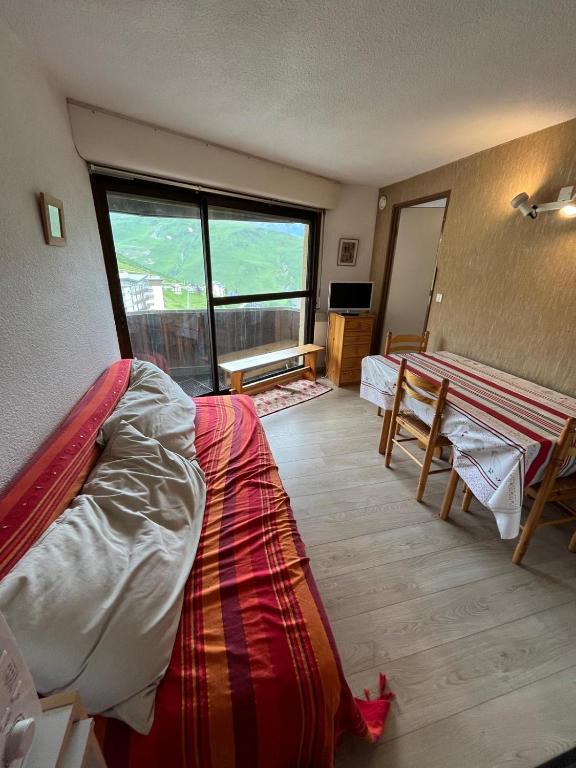 une chambre avec deux lits et une table et une fenêtre dans l'établissement Schuss Pied des Pistes!, à Saint-Lary-Soulan