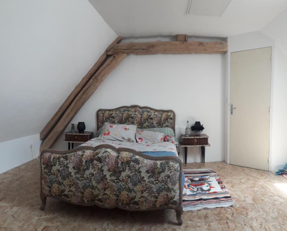 - une chambre mansardée avec un canapé et un lit dans l'établissement Naturart, à La Berthenoux