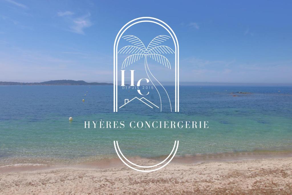 un panneau sur une plage près de l'eau dans l'établissement Côté Port T3 Clim pk Wifi Plage By HC, à Hyères