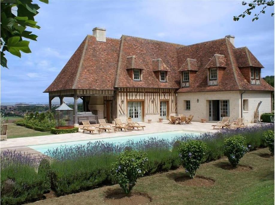 une grande maison avec une piscine en face de celle-ci dans l'établissement Amazing house - Sea view - Deauville, à Tourgéville