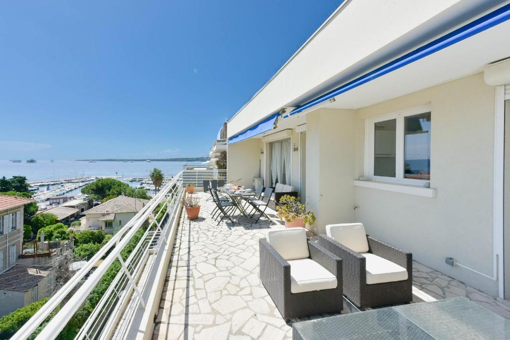 d'un balcon avec des chaises et une vue sur l'océan. dans l'établissement Cozy top-floor 2-Br apartment terrace and sea view, à Cannes