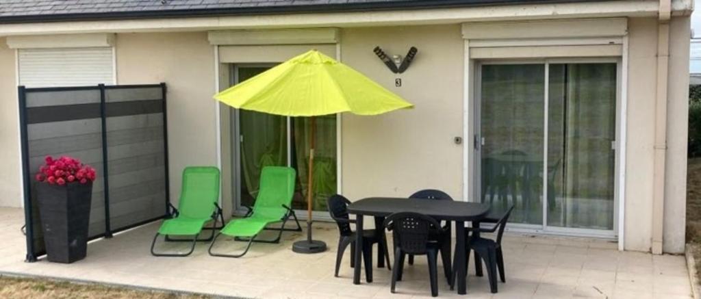 - une table et des chaises avec un parasol jaune sur la terrasse dans l'établissement Cozy nest close to the sea, au Pouliguen