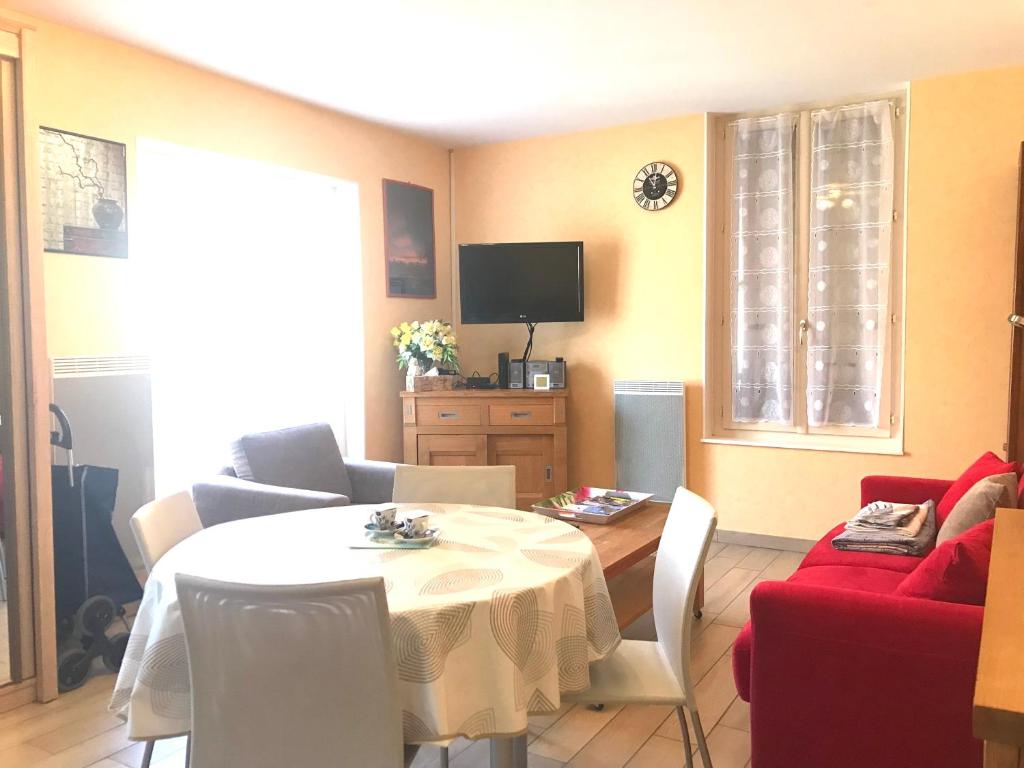 un salon avec une table et un canapé rouge dans l'établissement MAISON CHOLLET - Centre - Prox. Thermes - Terrasse, à Vichy