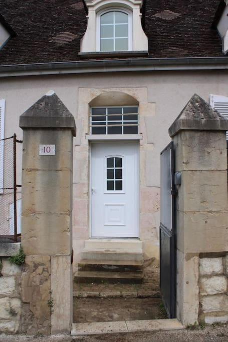 une maison avec une porte blanche et un portail dans l'établissement Le relais, à Prémeaux