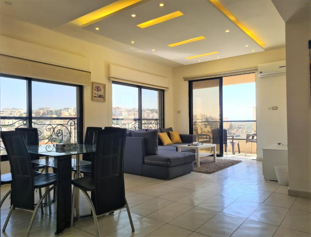a living room with a couch and a table at Dair Ghbar Gate Apartments in Amman
