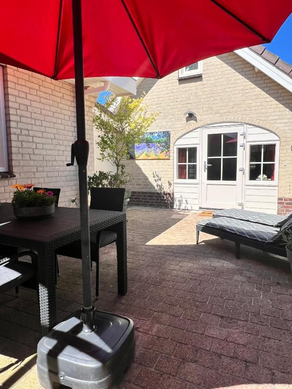 a red umbrella sitting on top of a table at De Spaier 3a in Zoutelande