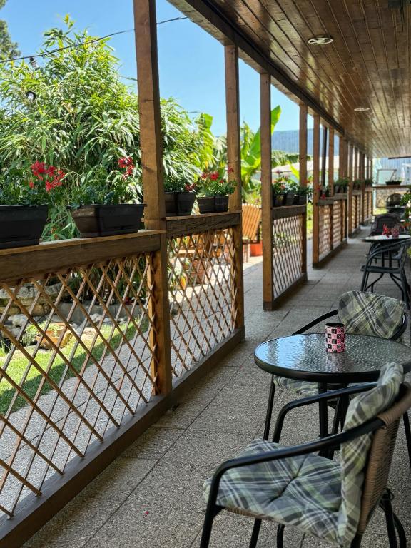 a patio with a table and chairs and plants at Lovin's Rooms in Tuzla