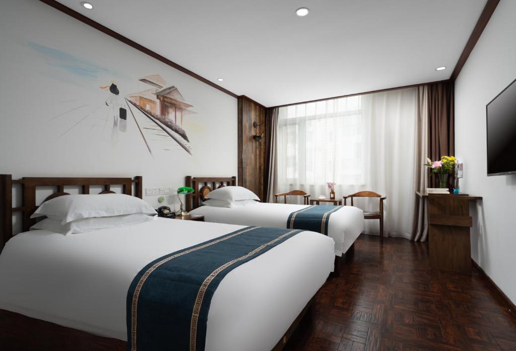 Ένα ή περισσότερα κρεβάτια σε δωμάτιο στο Nostalgia Hotel Tianjin Binhai Tanggu 时光漫步酒店天津滨海新区塘沽高铁站店 Free fresh ground coffee,Free laundry service