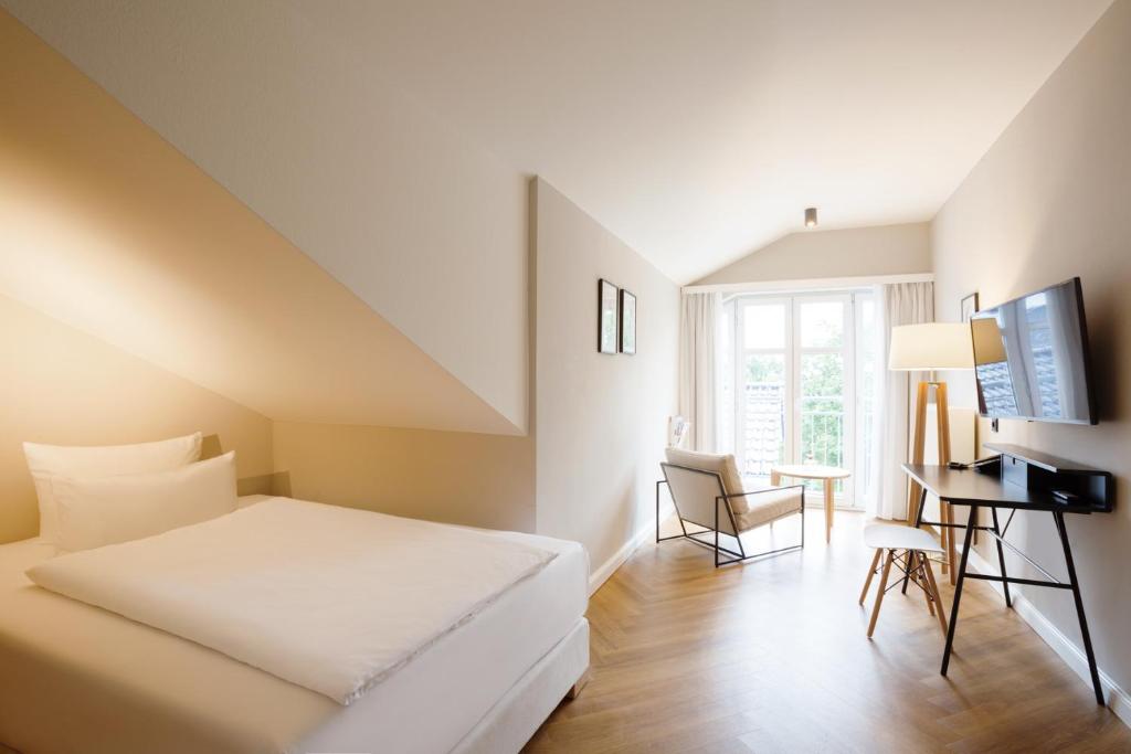a hotel room with a bed and a desk at Vju Hotel Rügen in Göhren