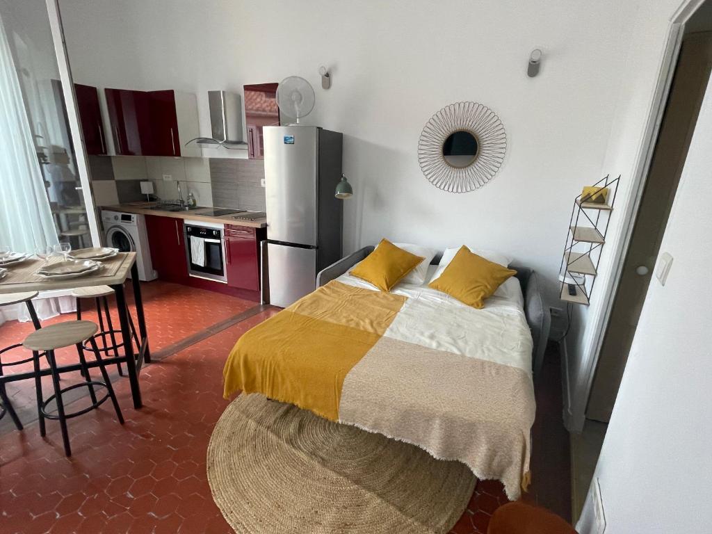 une petite chambre avec un lit et une cuisine dans l'établissement Bompard - Endoume - 2 Pièces - 5mn Vallon des Auffes, à Marseille