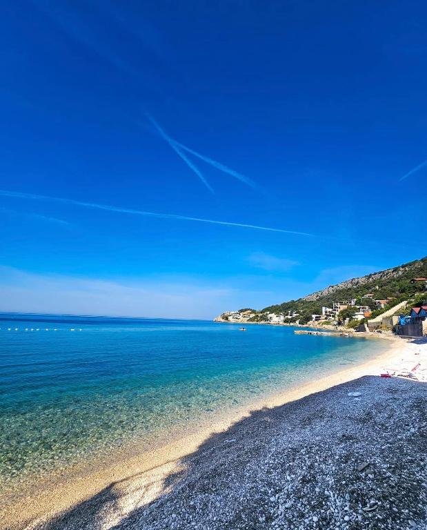 a beach with blue water and a blue sky at Apartmani Rakić in Ulcinj