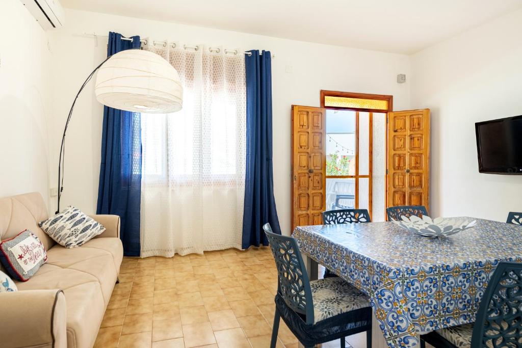 un soggiorno con un tavolo e un divano di Villa Bianca a Pulsano