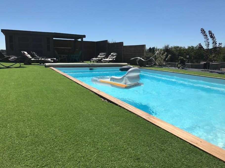 - une piscine entourée d'une pelouse dans l'établissement Maison entière location tourisme quatre étoiles proche de sites touristiques, à Le Roc