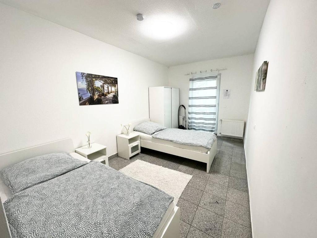 1 Schlafzimmer mit 2 Betten und einem Kühlschrank in der Unterkunft Work and Stay Apartment in Troisdorf in Troisdorf