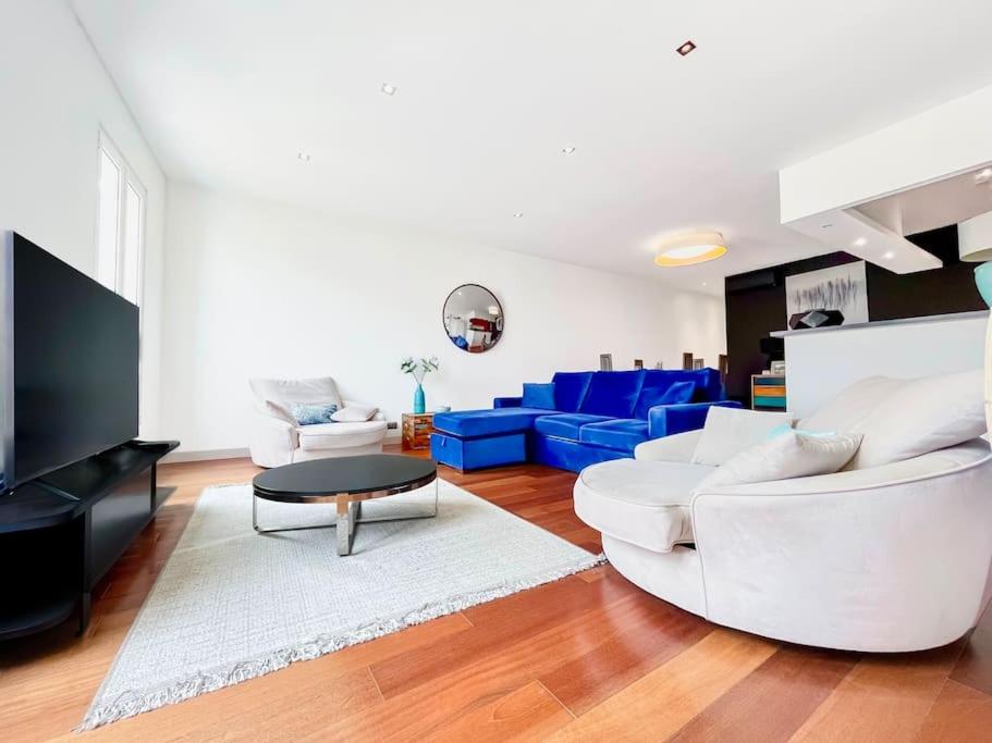 - un salon doté d'un mobilier blanc et d'un canapé bleu dans l'établissement Le Félix Faure - Palais Centre Cannes, à Cannes