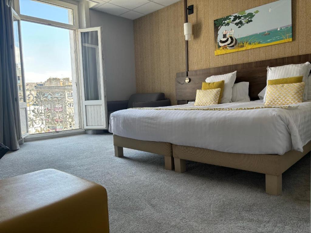 a bedroom with a large bed and a large window at Best Western Le Duguesclin Hôtel-Restaurant in Saint-Brieuc