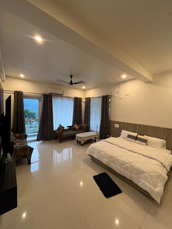 a large bedroom with a large bed and a couch at Hotel Kalyani in Nandaprayāg