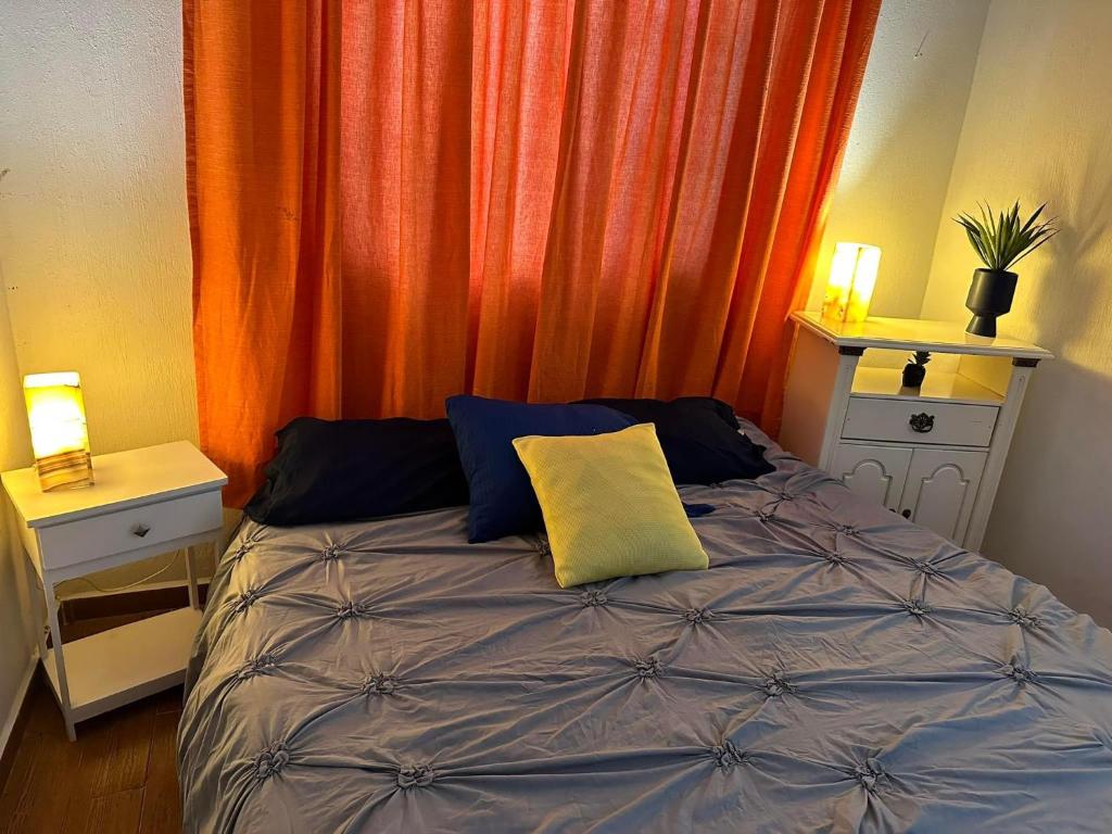 ein Schlafzimmer mit einem Bett mit einem gelben Kissen darauf in der Unterkunft Tenemos una casita en cancun in Cancún