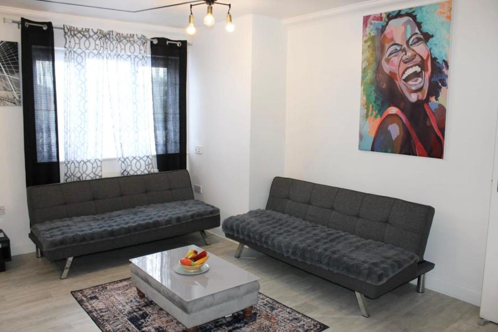 a living room with two couches and a painting at Bowery Apartment - 2 Bedrooms 1st floor in Dagenham