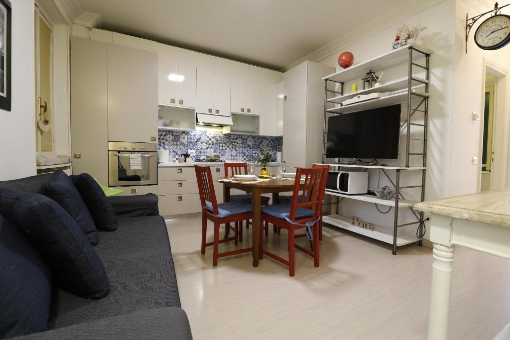 a living room with a couch and a table with chairs at Lovely Home Apartment in Lecco