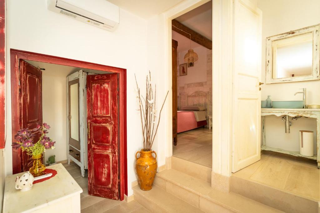 une chambre avec une porte rouge et un vase dans l'établissement Il Trullo Volza, à Locorotondo