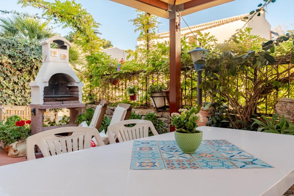 une table et des chaises blanches avec une maison ornithologique. dans l'établissement Villa Corallina Relais & Climbing Center, à San Vito Lo Capo