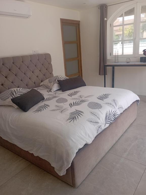 une chambre avec un lit avec une couette blanche dans l'établissement Chambre & plage & Spa & Piscine & wifi, à Valras-Plage