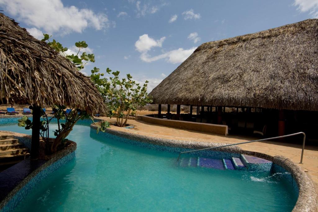 a resort with a swimming pool and a thatch roof at Samburu Sopa Lodge in Archers Post