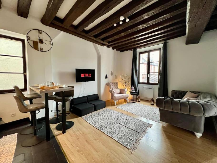 ein Wohnzimmer mit Tisch und Couch in der Unterkunft Nid de Montereau - Centre - 4 personnes in Montereau-faut-Yonne