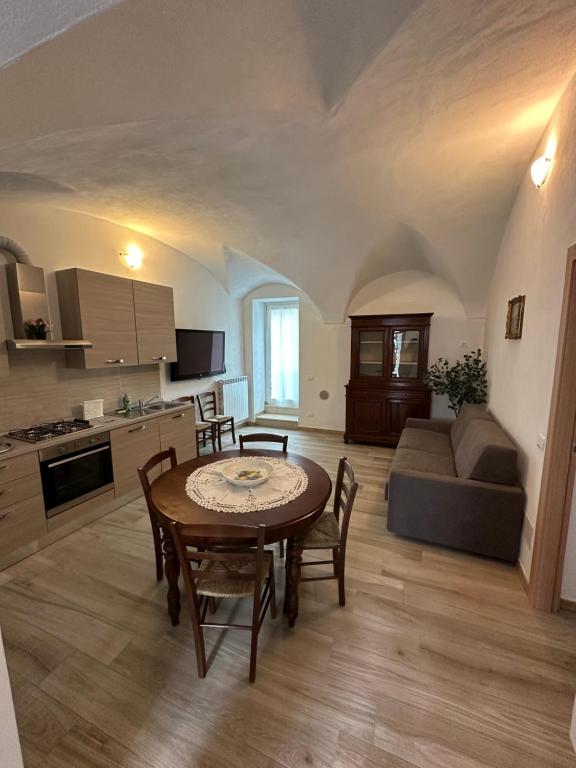 una cucina e un soggiorno con tavolo e divano di Borgo nel Vigneto a Erbusco