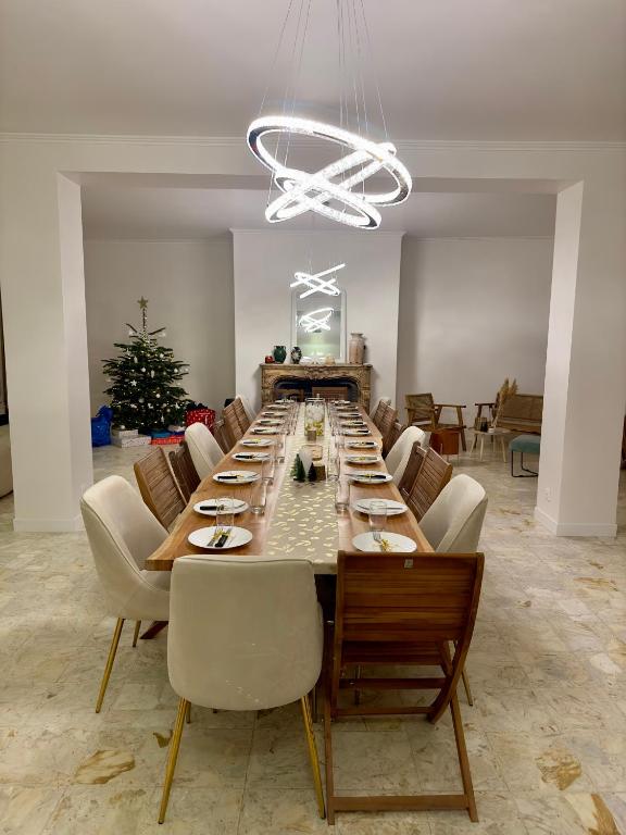 une grande salle à manger avec une longue table et des chaises dans l'établissement La Villa Bourgeoise, à Croisilles