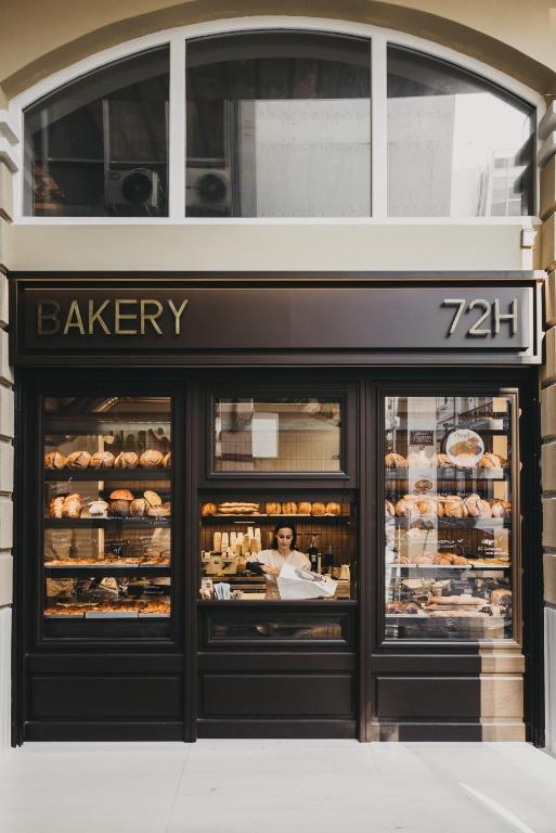 a bakery store front with a woman in the window at Ergon Bakehouse Athens in Athens