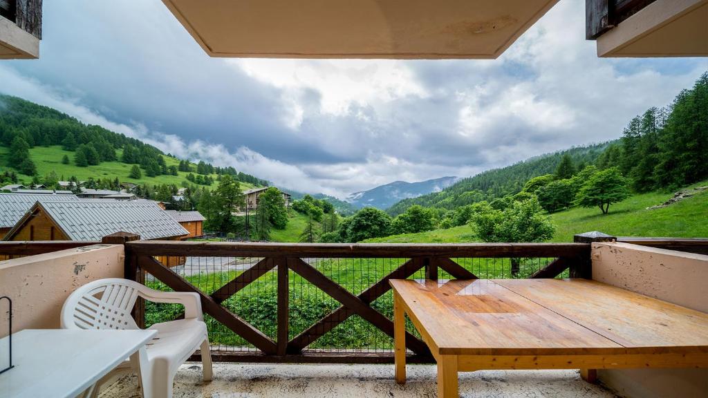 d'une table et de chaises en bois sur un balcon avec vue. dans l'établissement LE SCHUSS 5 - 28 Studio cabine 4 pers, à La Foux