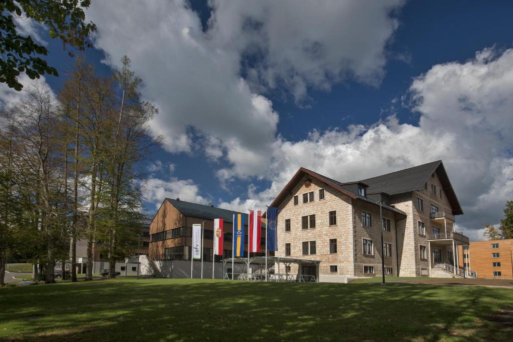un edificio con bandiere colorate su un lato di Waldcampus Österreich a Traunkirchen