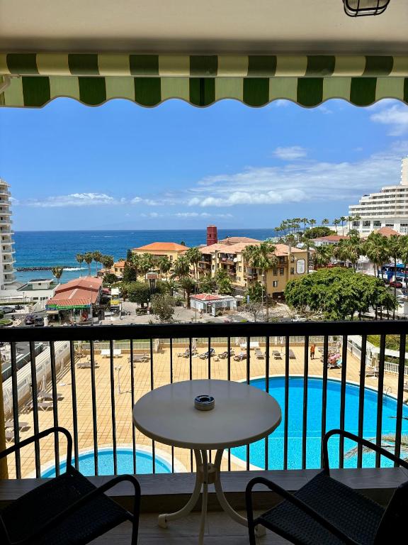 a balcony with a table and a view of the beach at Sunset Copacabana in Playa Fañabe