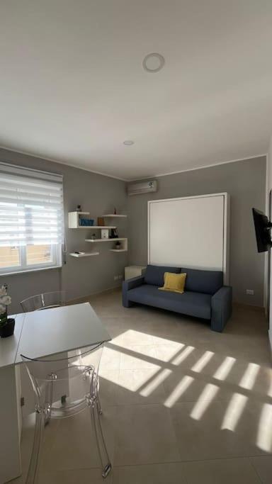 a living room with a blue couch and a window at Casa Colò in Naples