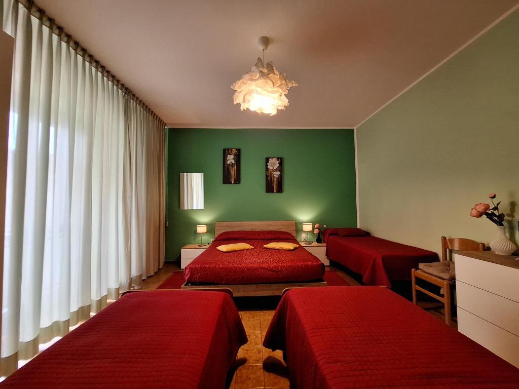 a bedroom with two red beds and a green wall at Bed & Breakfast "Il Ghiro" in San Martino sulla Marruccina