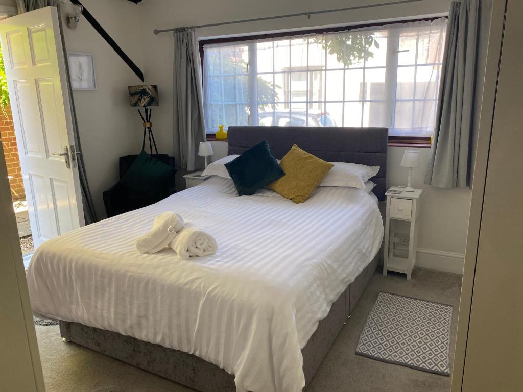 a bedroom with a large bed with towels on it at Coachmans Rest in Sandwich