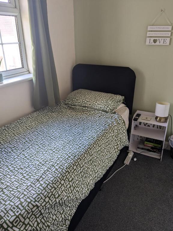 a small bedroom with a bed and a window at Small but bright single room not far from City Centre in Leicester