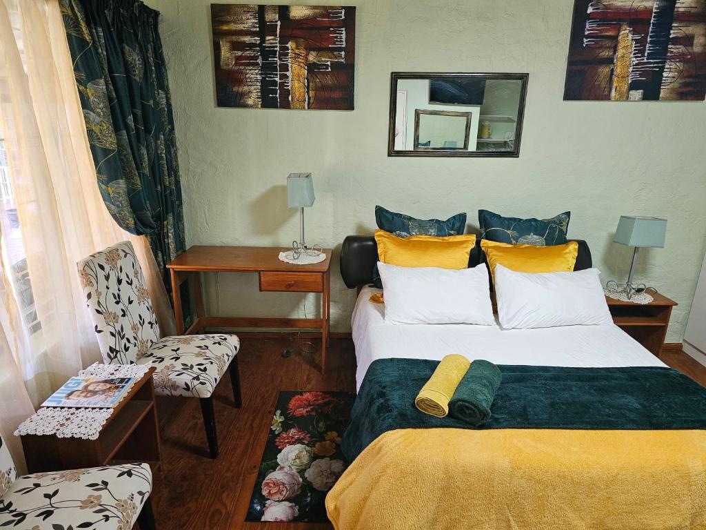 a hotel room with a bed and a chair at King Sanctuary in Centurion
