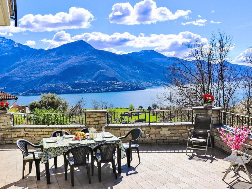 a table and chairs on a patio with a view of a lake at Apartment Raggio di Sole Apartment A by Interhome in Consiglio di Rumo