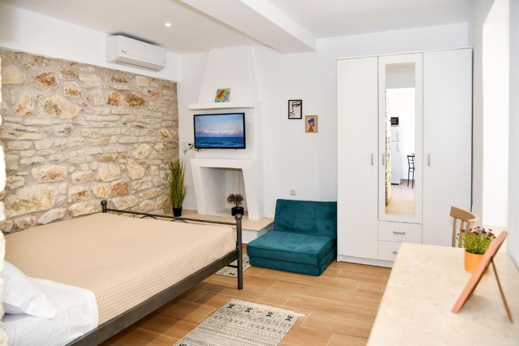 a bedroom with a bed and a blue chair at Captain theo apartment Annoula in Lefkímmi